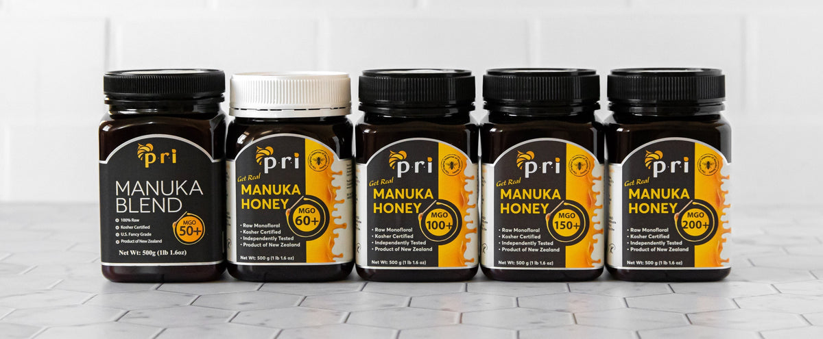 Assorted jars of New Zealand Manuka honey and Manuka blend on a tiled surface