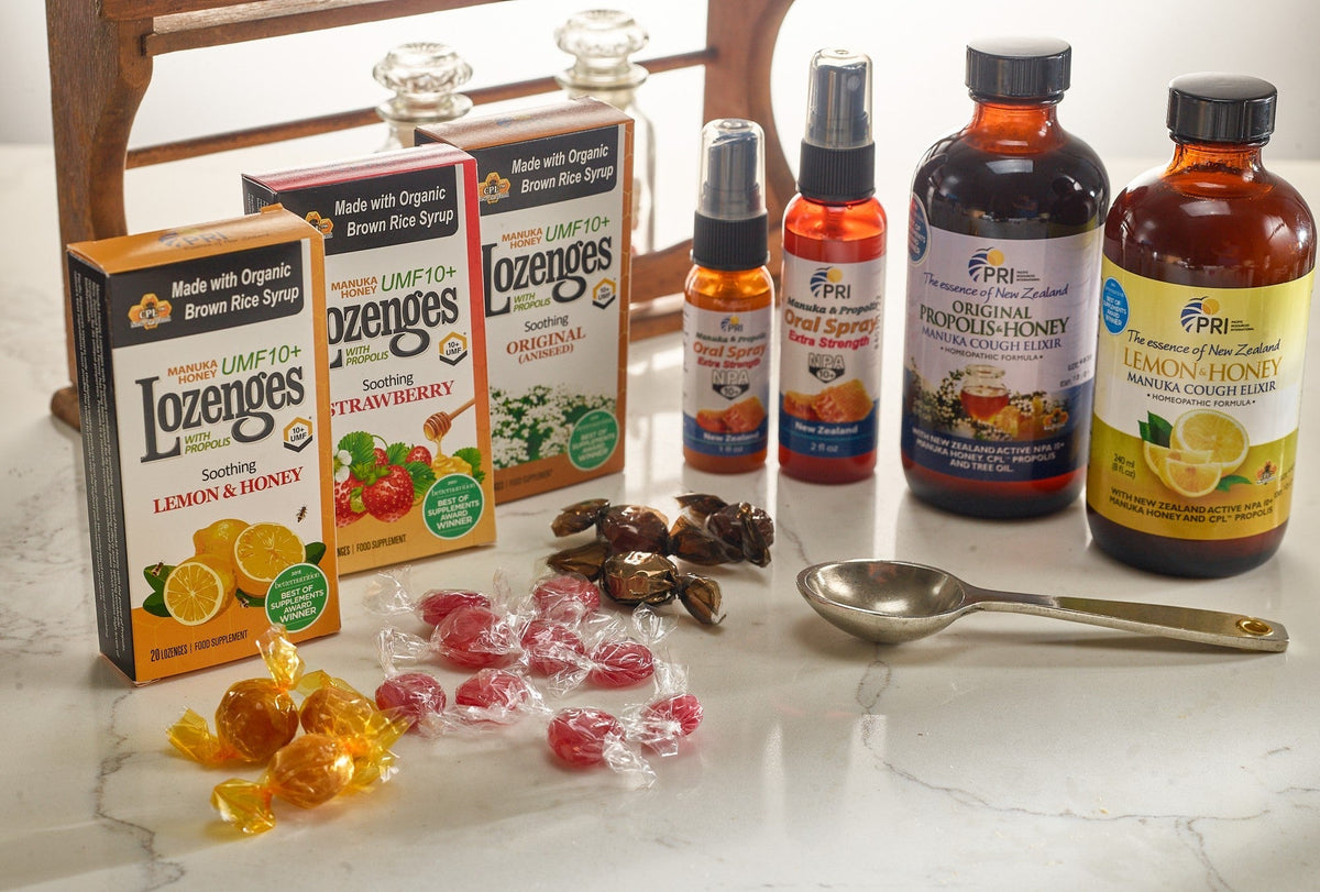 Assorted Manuka honey health products including lozenges, cough elixirs, and oral sprays on a counter.