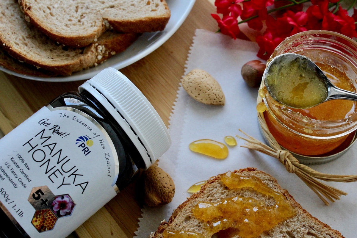 Manuka honey jar, honey on whole grain bread with nuts and flowers