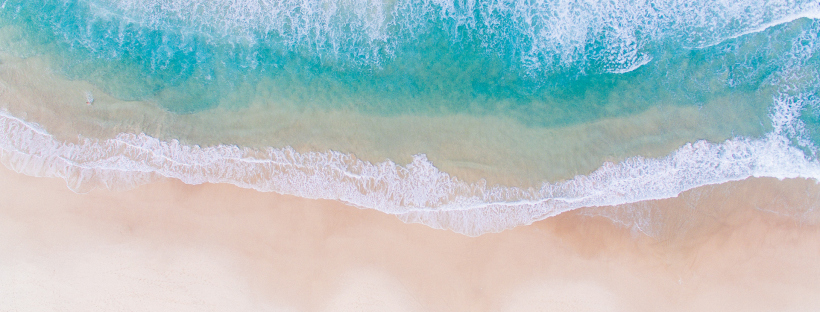 Aerial view of Pacific ocean waves meeting sandy beach, illustrating natural sea salt source.