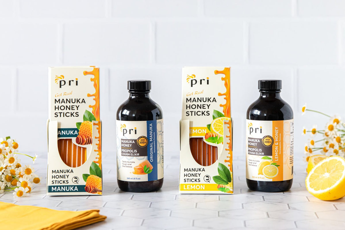 Manuka honey sticks and propolis cough elixir bottles with lemon and chamomile flowers